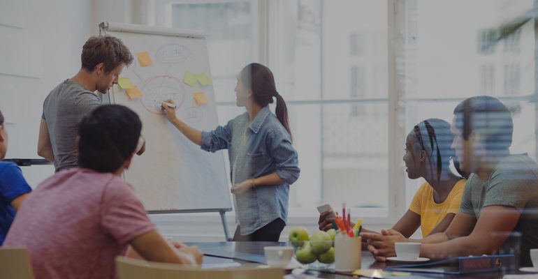 Business executives discussing with their colleagues on whiteboard